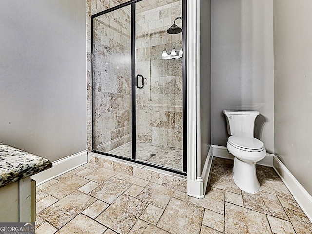 full bathroom with baseboards, a stall shower, and stone tile floors