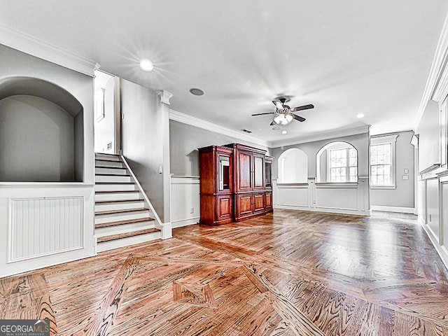 interior space featuring ceiling fan, parquet flooring, and ornamental molding