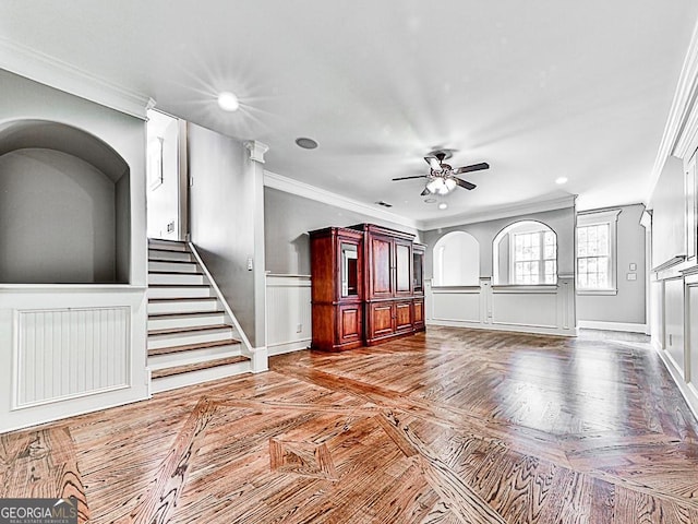 unfurnished living room with crown molding, a ceiling fan, recessed lighting, stairway, and baseboards