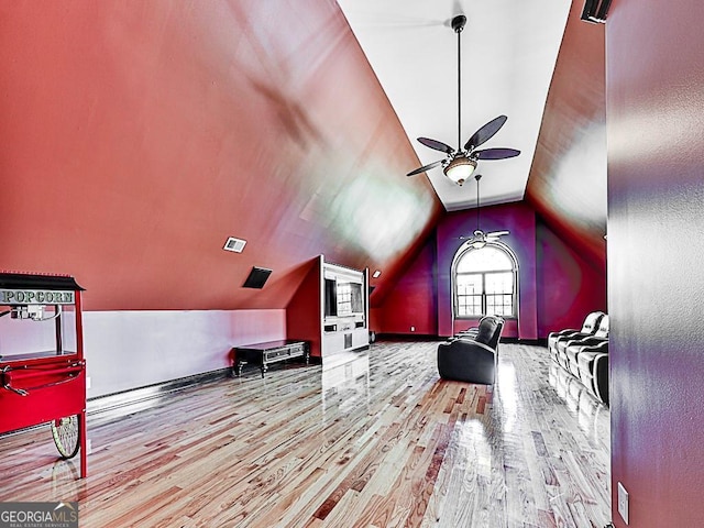 interior space with ceiling fan, wood-type flooring, and vaulted ceiling