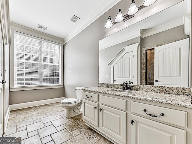 bathroom with stone tile flooring, baseboards, crown molding, toilet, and vanity