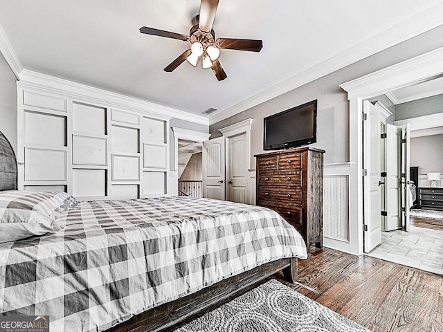 bedroom with crown molding, ceiling fan, and wood finished floors