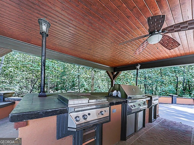 view of patio / terrace featuring exterior kitchen, ceiling fan, and area for grilling