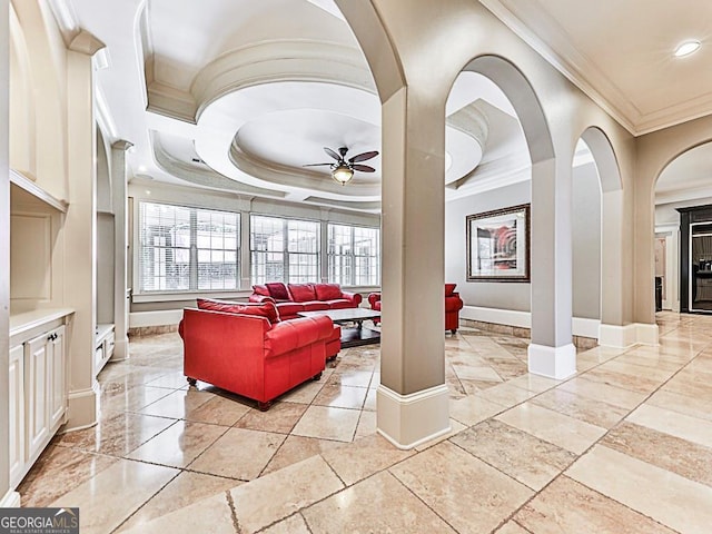 living room with a tray ceiling, ceiling fan, and crown molding