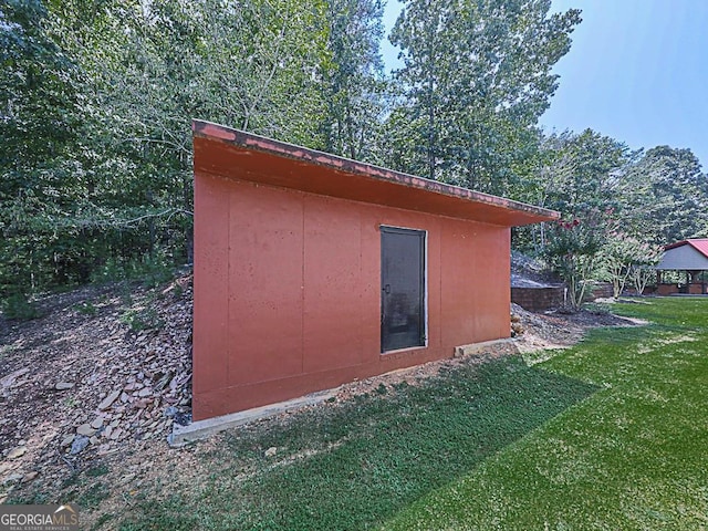 view of outbuilding with a lawn