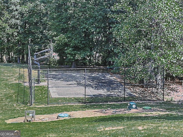 view of tennis court with a yard