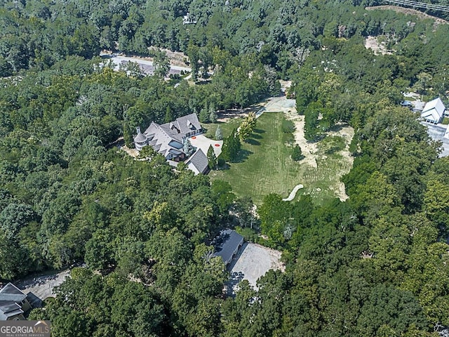 aerial view of property's location featuring a forest
