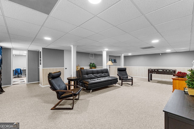 carpeted living room featuring a drop ceiling