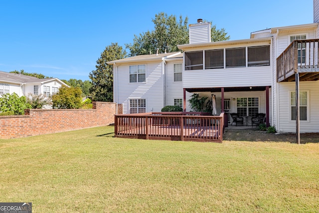 rear view of house featuring a deck, a lawn, and a patio