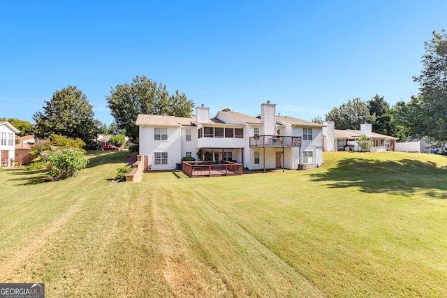 back of house with a wooden deck and a lawn