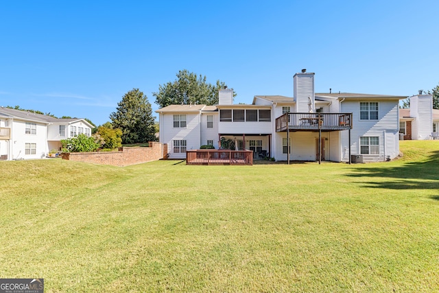 rear view of property featuring a lawn and a wooden deck