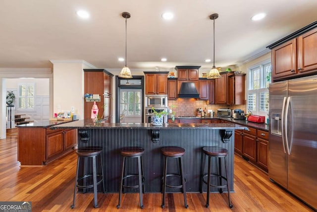 kitchen featuring appliances with stainless steel finishes, plenty of natural light, and dark stone counters