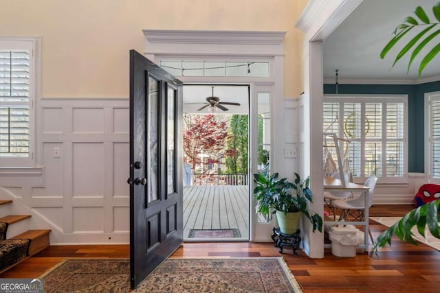 entrance foyer with ornamental molding, plenty of natural light, and hardwood / wood-style floors