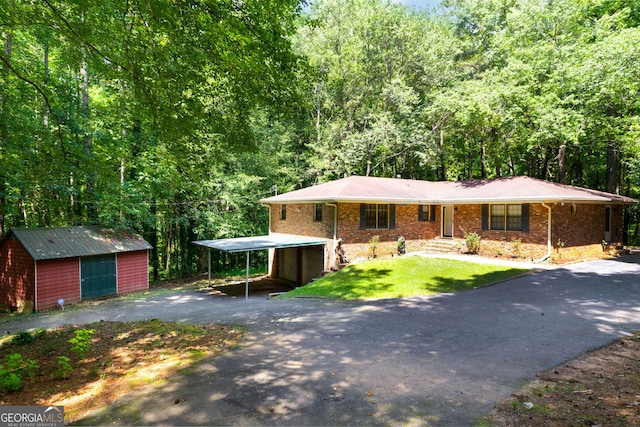 view of front of house featuring a carport, a shed, and a front yard