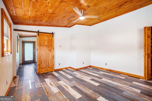 empty room with wooden ceiling, a barn door, vaulted ceiling, dark hardwood / wood-style flooring, and ceiling fan