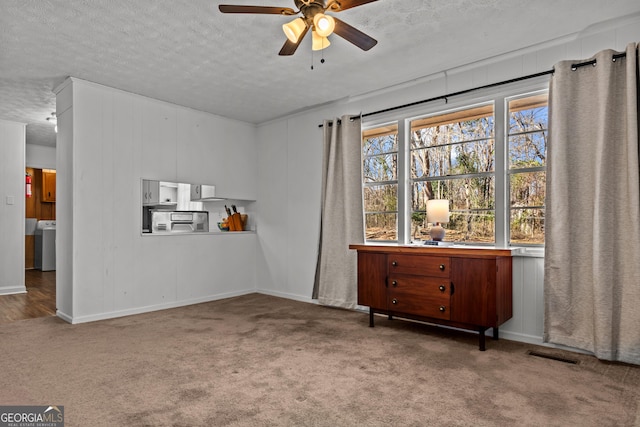 carpeted empty room with ceiling fan, washer / clothes dryer, and a textured ceiling