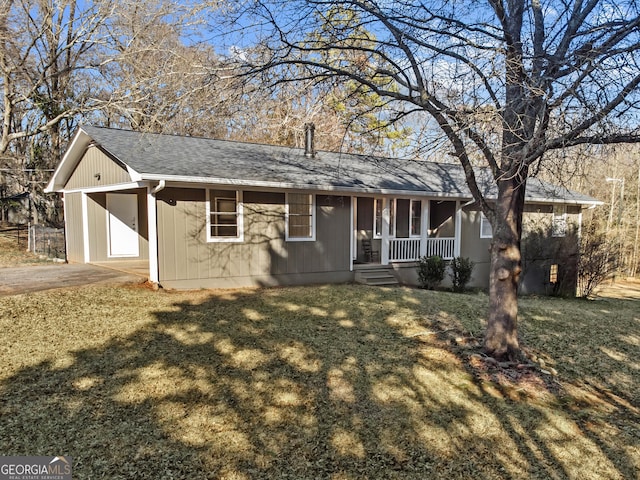 ranch-style house featuring a front lawn, a carport, and a porch