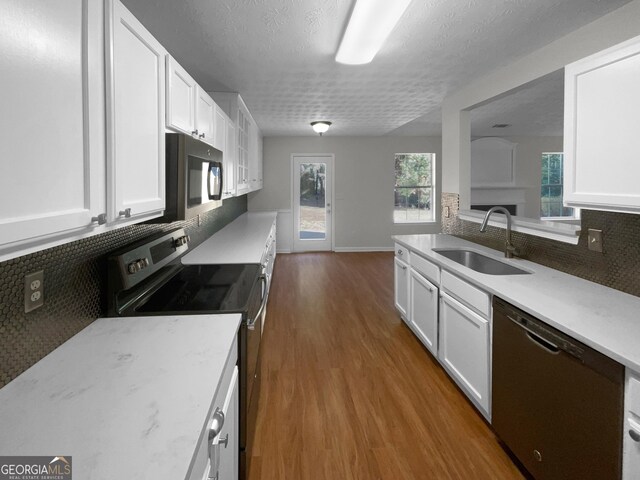 kitchen with stainless steel appliances, dark hardwood / wood-style flooring, white cabinetry, and sink