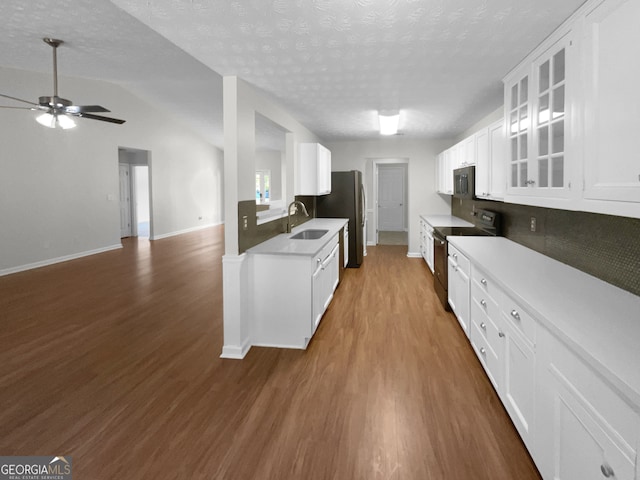 kitchen featuring range with electric cooktop, sink, white cabinetry, lofted ceiling, and ceiling fan