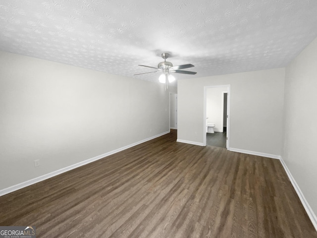 unfurnished bedroom featuring a ceiling fan, a textured ceiling, baseboards, and dark wood-type flooring