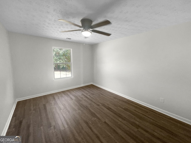 unfurnished room with visible vents, dark wood-type flooring, ceiling fan, a textured ceiling, and baseboards