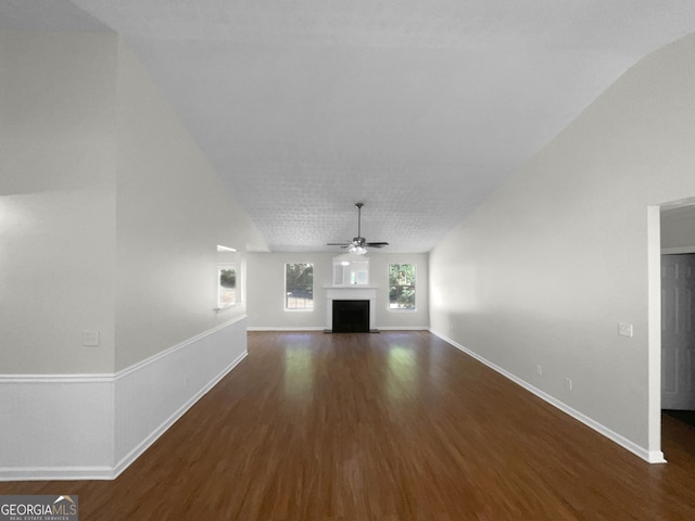 unfurnished living room featuring a ceiling fan, a fireplace, baseboards, and wood finished floors