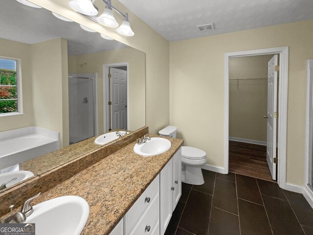 full bathroom featuring toilet, tile patterned flooring, vanity, a textured ceiling, and shower with separate bathtub