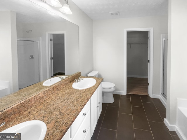 bathroom featuring baseboards, a sink, visible vents, and a shower stall