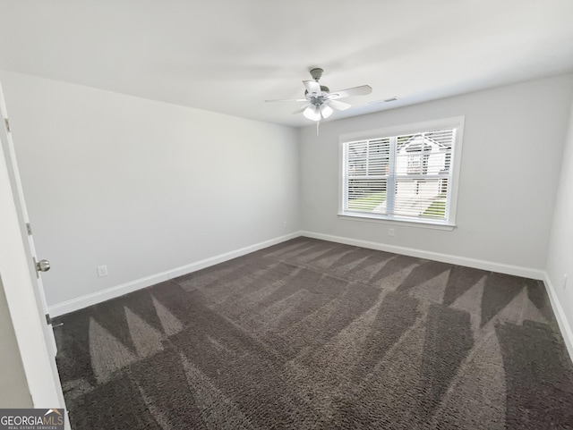 spare room with ceiling fan, visible vents, baseboards, and dark colored carpet