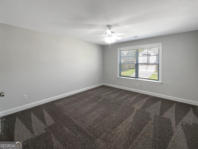 spare room featuring a ceiling fan, visible vents, dark carpet, and baseboards