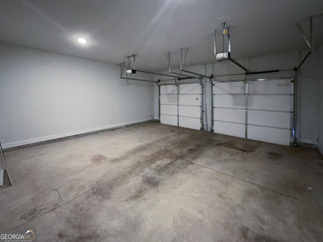 garage featuring a garage door opener and baseboards