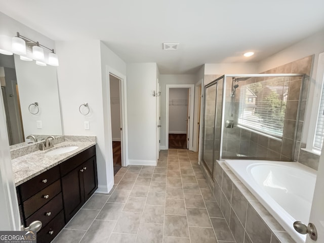 full bath featuring a garden tub, a shower stall, vanity, and tile patterned floors