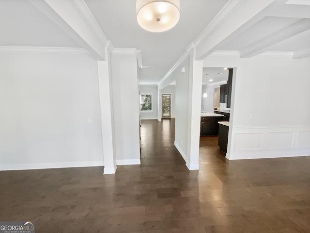 hallway with dark wood-type flooring, a decorative wall, and ornamental molding