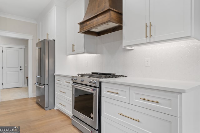 kitchen with white cabinets, custom range hood, light wood-type flooring, and high end appliances