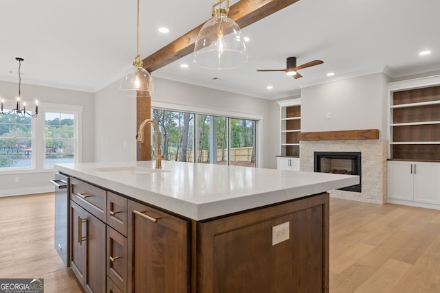 kitchen featuring a wealth of natural light, sink, an island with sink, and light hardwood / wood-style flooring