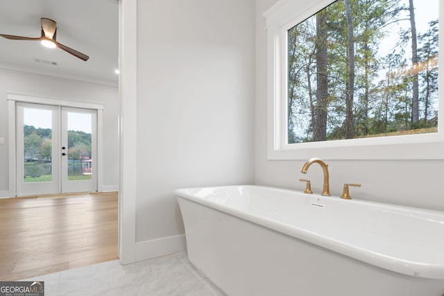 bathroom featuring a tub, ceiling fan, french doors, and hardwood / wood-style flooring