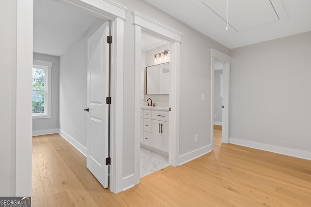 corridor with sink and light wood-type flooring