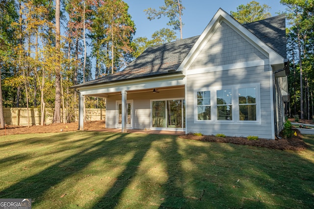 back of house featuring a lawn and ceiling fan