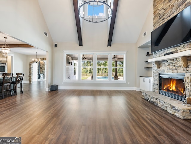 unfurnished living room featuring a fireplace, high vaulted ceiling, an inviting chandelier, and dark hardwood / wood-style floors