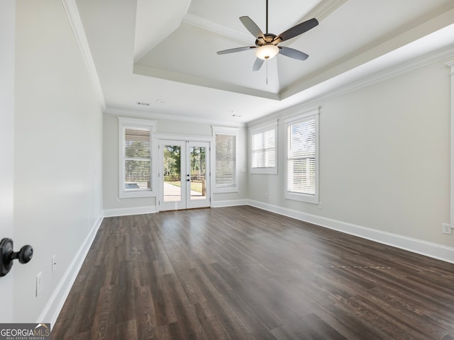 spare room with a raised ceiling, ceiling fan, french doors, and dark wood-type flooring