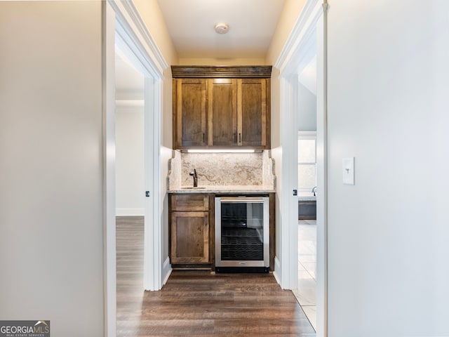 bar with beverage cooler, dark hardwood / wood-style floors, backsplash, and sink