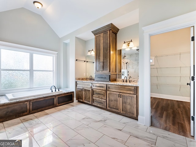 bathroom with vanity, vaulted ceiling, and shower with separate bathtub