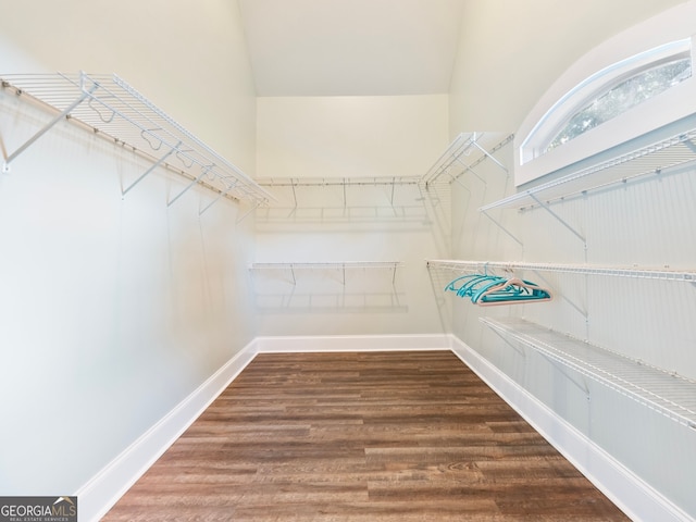 walk in closet with hardwood / wood-style floors and a high ceiling