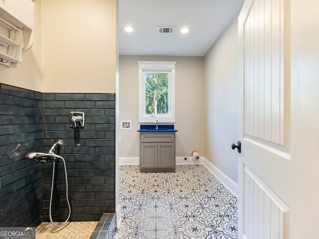 bathroom with vanity, a shower, and tile patterned floors