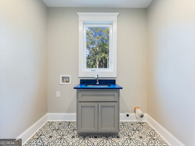 laundry area with light tile patterned floors, hookup for a washing machine, sink, and electric dryer hookup