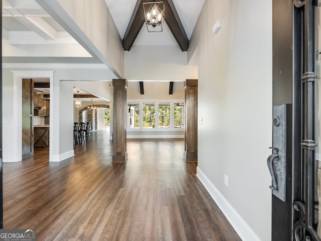 foyer featuring dark hardwood / wood-style flooring, a chandelier, ornate columns, and beam ceiling