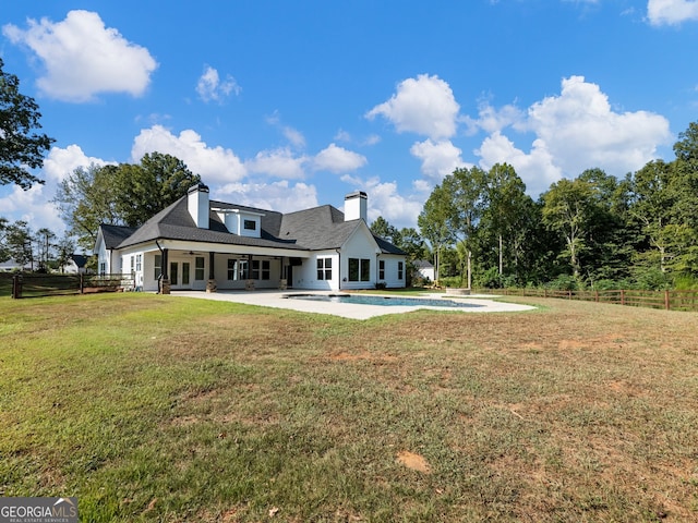 rear view of property featuring a lawn and a patio