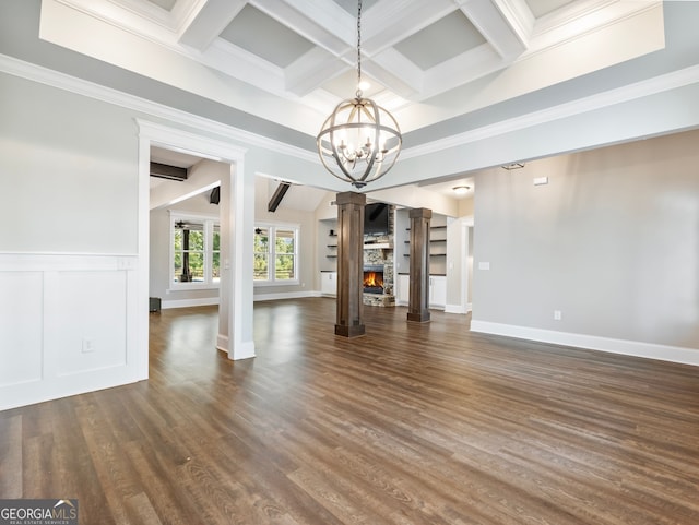 unfurnished living room featuring a fireplace, dark hardwood / wood-style floors, a chandelier, and ornamental molding