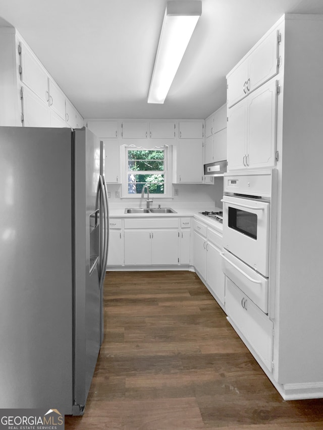 kitchen featuring white cabinetry, white appliances, dark hardwood / wood-style flooring, and sink