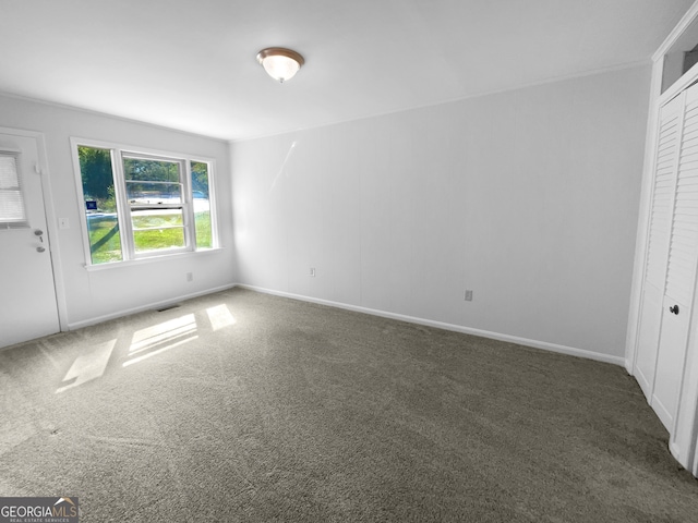 unfurnished bedroom with a closet and dark colored carpet